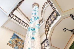 ein Weihnachtsbaum in der Lobby eines Gebäudes in der Unterkunft Ortea Palace Hotel, Sicily, Autograph Collection in Syrakus