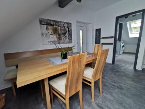 uma sala de jantar com uma mesa de madeira e cadeiras em Skyline klimatisierte Dachgeschoss-Wohnung in Dornbirn mit Blick ins Rheintal em Dornbirn