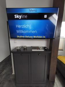 uma televisão em cima de um suporte com uma mesa em Skyline klimatisierte Dachgeschoss-Wohnung in Dornbirn mit Blick ins Rheintal em Dornbirn