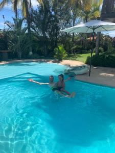 due persone sono sedute in una piscina di Casa Swell Coronado A unique blend of luxury and nature in the hearth of Coronado a Playa Coronado