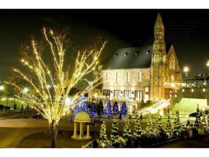 um grande edifício com luzes de Natal em frente em Hotel Sunlife Garden - Vacation STAY 55411v em Hiratsuka