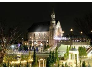 um grande edifício com uma torre de relógio à noite em Hotel Sunlife Garden - Vacation STAY 55411v em Hiratsuka