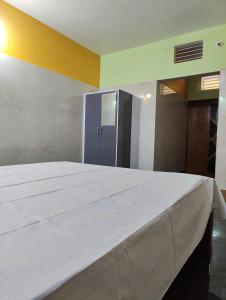 a large white bed in a room with a yellow wall at Jagannatha Guest House in Puri