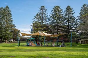 um parque com parque infantil com escorrega e árvores em The Farmer s Retreat em Kiama