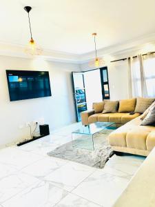 ein Wohnzimmer mit 2 Sofas und einem Flachbild-TV in der Unterkunft TETEK Residential Home in Swakopmund