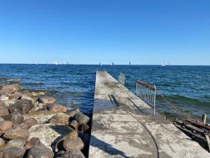 un muelle con rocas y veleros en el agua en Stor och lyxig villa mitt i Visby innerstad, en Visby