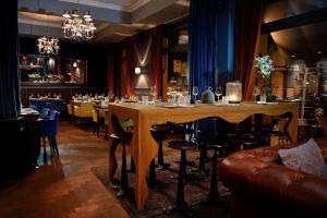 een bar met een grote houten tafel en stoelen bij Syte Boutique Hotel Mannheim in Mannheim