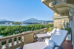 balkon z krzesłami i widokiem na wodę w obiekcie Grand Hotel National Luzern w Lucernie