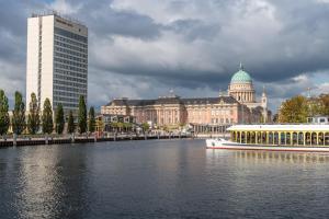 łódź na rzece przed budynkiem w obiekcie Mercure Hotel Potsdam City w Poczdamie