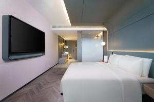 蘭州市にあるAtour S Hotel Lanzhou Asia-Europe International High Altitudeのベッドルーム(白いベッド1台、薄型テレビ付)