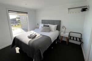 um quarto com uma cama com uma toalha em BINALONG BRAE @ Bay of Fires Two bedroom both with ensuites em Binalong Bay