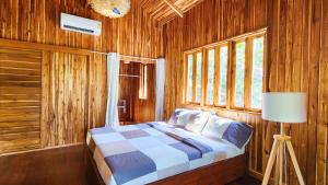 - une chambre avec un lit dans une pièce en bois dans l'établissement Baan Bhuwann Forest Chalet, à Ko Pha Ngan