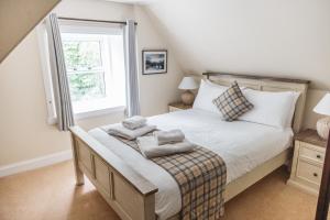 1 dormitorio con 1 cama con toallas en Greshornish House Hotel en Edinbain