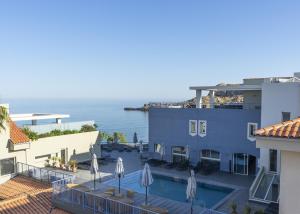 vista su un hotel con piscina e sull'oceano di Best Western Premier Santa Maria a LʼÎle-Rousse