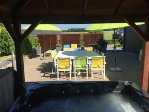 een patio met een tafel en stoelen en een parasol bij Chalet Ardenne in Rochehaut