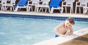 a young child standing in a swimming pool at Williamsburg Woodlands Hotel & Suites, an official Colonial Williamsburg Hotel in Williamsburg