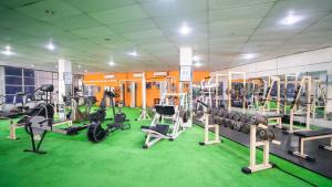 un gimnasio con cintas de correr y máquinas en un suelo verde en Quest Colombo Residencies, en Talawatugoda