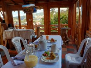 a table with two plates of food and orange juice at ATALLARO Hospedaje in Otavalo