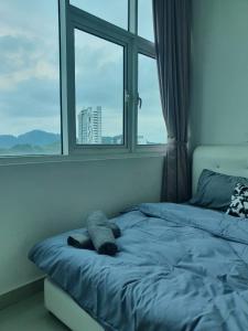 Cama en habitación con ventana grande en Seaview Condo 10pax #10minQueensbay #15minSpice en Bayan Lepas