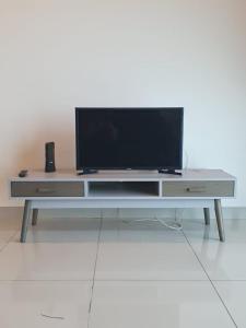 un centro de entretenimiento con TV de pantalla plana. en Seaview Condo 10pax #10minQueensbay #15minSpice en Bayan Lepas