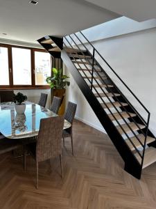 een eetkamer met een glazen tafel en een trap bij Luxury PENTHOUSE at the Historical Centre with free parking in Bratislava