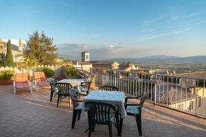 un patio con mesas y sillas en el balcón en Hotel Umbra en Assisi