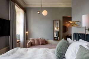 een slaapkamer met een bed, een stoel en een spiegel bij Hotel Frantz, WorldHotels Crafted in Stockholm