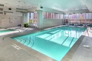 een groot zwembad met blauw water in een gebouw bij Hilton Garden Inn Calgary Downtown in Calgary