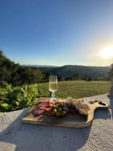 una tabla de cortar de madera con comida y una copa de vino en Zerko Holiday Home - Vineyard Chalet With Sauna and Jacuzzi FREE en Mirna