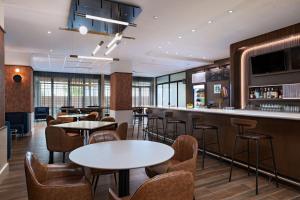 um restaurante com mesas e cadeiras e um bar em Courtyard by Marriott Austin Dripping Springs em Dripping Springs