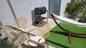 een patio met stoelen, een hangmat en een grill bij Apartamento EL REAL - Espartinas - SEVILLA in Espartinas