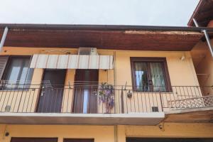 edificio giallo con balcone e finestra di Bilocale accogliente tra Como e Milano a Saronno