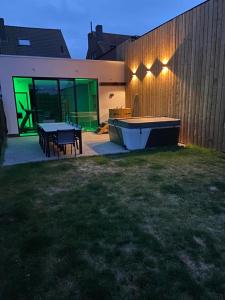 un cortile con tavolo da ping pong e recinto con luci di Vakantiehuis Joanitas a Bredene