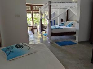 um quarto com 2 camas e uma sala de estar em Villa Lyvie ayurvedic hotel em Tangalle