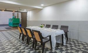 een eetkamer met een tafel en stoelen bij Treebo Oscar in Rajkot