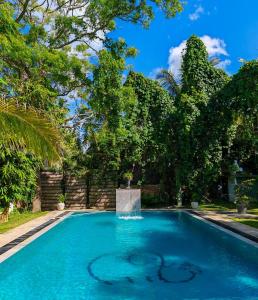 uma piscina com uma fonte num quintal com árvores em Villa Lyvie ayurvedic hotel em Tangalle