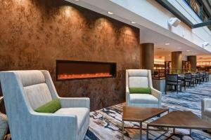 una hall con due sedie e un camino di Embassy Suites by Hilton Minneapolis Airport a Bloomington