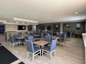 um restaurante com mesas e cadeiras e um bar em Comfort Suites Seabrook - Kemah em Seabrook