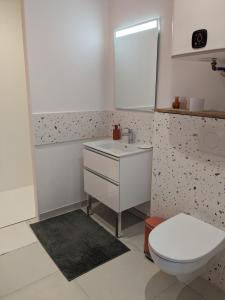 bagno con servizi igienici bianchi e lavandino di L'atelier: charmante annexe indépendante a Mâcon