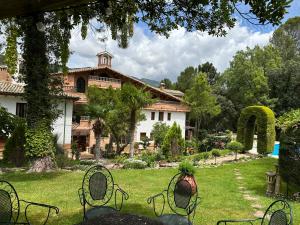 ein Haus mit einem Garten mit Stühlen davor in der Unterkunft Hotel Rural Convento Santa Maria de la Sierra in Arroyo Frio