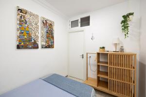 een slaapkamer met een bed en een schilderij aan de muur bij Kite & Surf Nomad House in Las Palmas de Gran Canaria