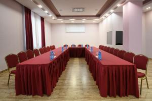 - une longue table dans une chambre avec des rideaux et des chaises rouges dans l'établissement Alpina Resort by Stellar Hotels, Tsaghkadzor, à Tsaghkadzor