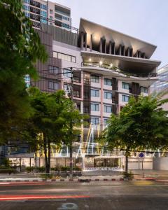 een hoog gebouw met een straat ervoor bij Samyan Serene Hotel in Bangkok