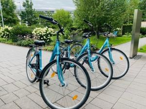 drie fietsen geparkeerd naast elkaar op een stoep bij Motel One Hamburg am Michel in Hamburg