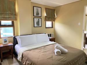 1 dormitorio con 1 cama con toallas en Crosswinds Resort One Bedroom Condo Suite en Tagaytay