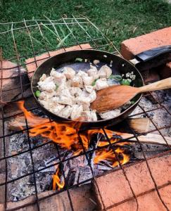 una sartén de comida cocinando en un campamento de fuego en Hilltop Bungalow, en Mirissa