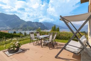 un patio con mesa, sillas y montañas en Villa La Perla - Bellagio en Bellagio