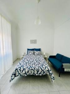 - une chambre avec un lit et un canapé bleu dans l'établissement Casa da Salúquia, à Moura