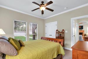 1 dormitorio con 1 cama y ventilador de techo en Deer Haus Retreat, en New Braunfels