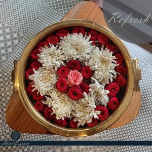 a bouquet of red and white flowers in a wooden bowl at Hotel ESSENCE in Vellore